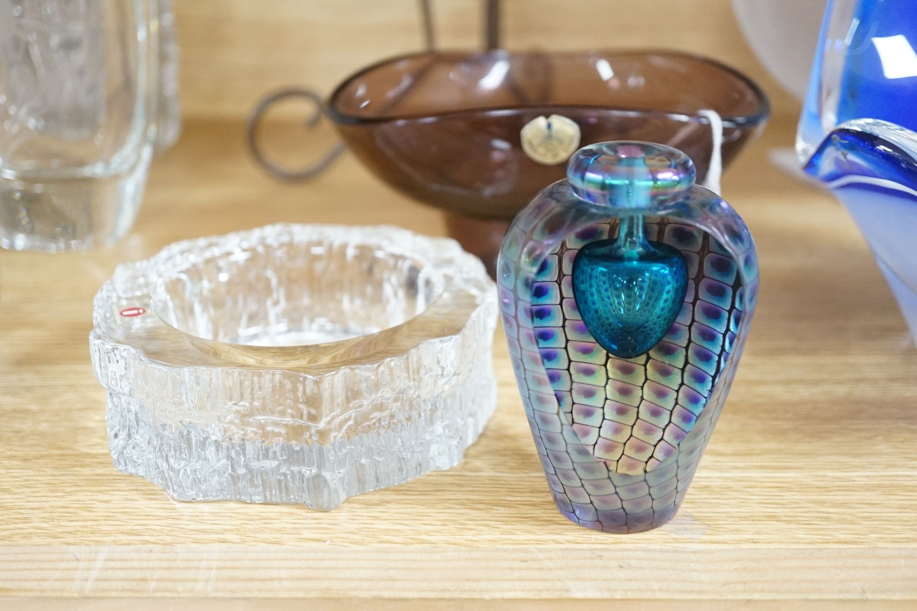 A frosted art glass bowl on stand with ‘face’ pattern to base together with an Iitalla map ash tray designed by Tapio Wirkkala, a bohemian iron and spatter pattern glass shade oil lamp, Tom Philabaum art glass perfume bo